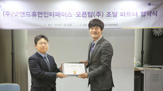 지난 25일 서울 영등포 넷앤드휴먼인터페이스 본사에서 신호철 넷앤드휴먼인터페이스 대표(오른쪽)와 이동하 오픈탑 대표가 업무협약을 맺고 기념촬영을 하고 있다.